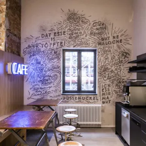 In the agency kitchen with rustic craft stools, slogans fitting for the region were applied to the wall around the window with black charcoal-look pens