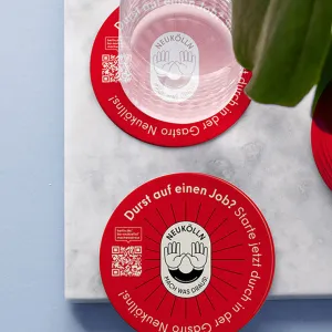 Red round beer coasters printed with the campaign logo, QR code and the text: 