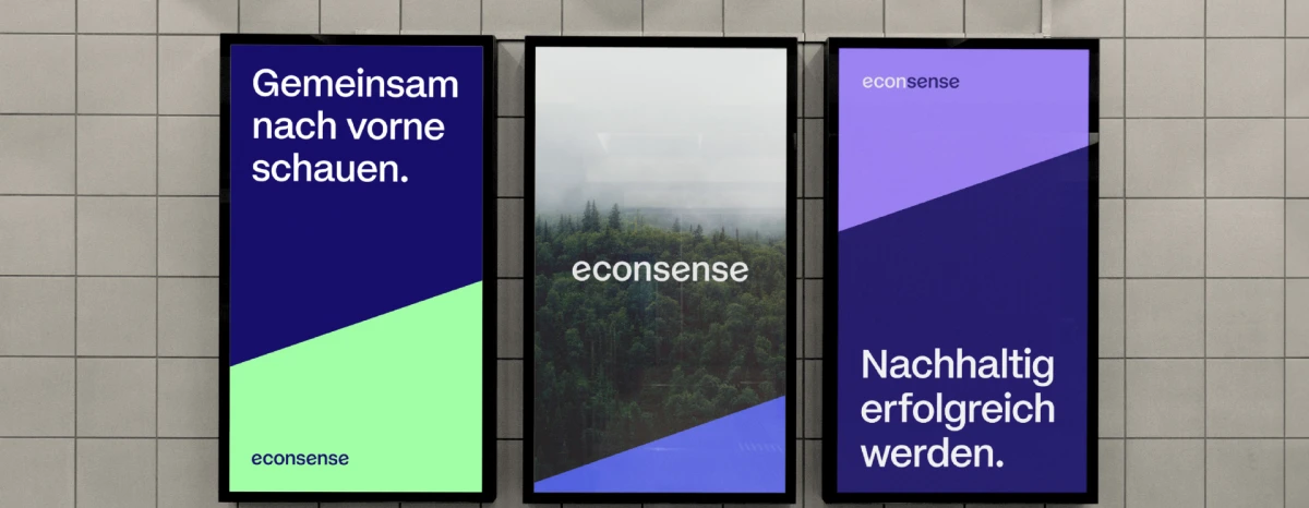 Three illuminated posters in blue and green tones featuring a nature motif and the messages “Looking ahead together.” and “Achieving sustainable success.”