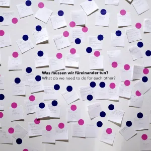 Wand voller Klebezettel mit Antworten der Ausstellungsbesuchenden auf die Frage 