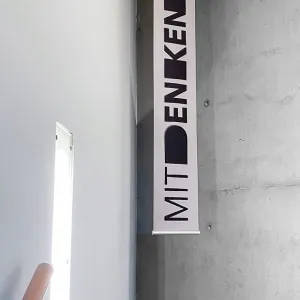 Banner hanging from the ceiling with black text 