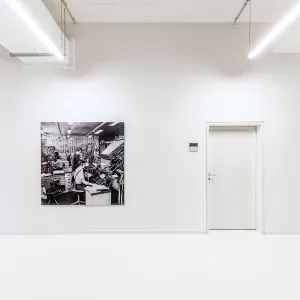 Historical large-format black and white photographs are placed along the white wall of the corridor, giving an insight behind the scenes of the Märkische Allgemeine Zeitung