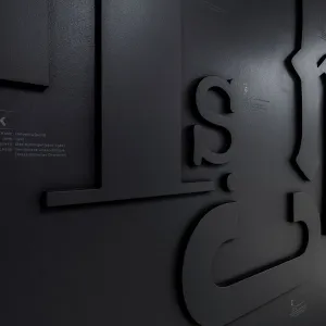 Between black haptic letters on the black wall, short information texts about each of the fonts shown can be read in white next to them