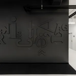 Large black letters in different fonts were attached to the black wall in the hallway, the letters are partially tilted to form a letter surface, from left to right the letters form the text: Märkische Allgemeine