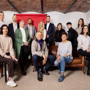 MPW Immobilien Team smiling, in front of red background