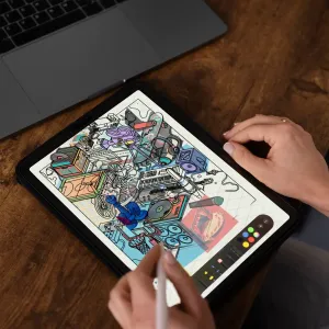 Eine Person zeichnet mit einem Apple Pencil auf einem iPad, das auf einem Holztisch liegt. Auf dem iPad ist die Benutzeroberfläche von Procreate sichtbar, während eine kollegenartige Entwurfsskizze illustriert wird. Neben dem iPad steht ein aufgeklappter Apple MacBook-Laptop. Von der Person sind nur die Hände zu sehen.