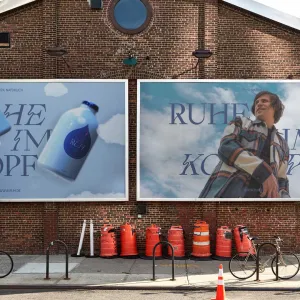 Out-of-Home Plakate werben für die blaue RUH Variante, mit dekorativen Wolkenelementen und dunkelblauer geschwungener Schrift