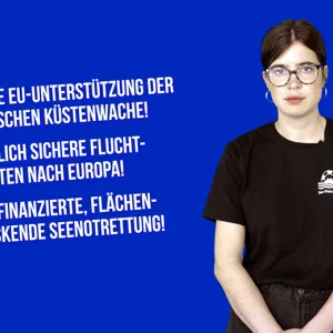 Videoausschnitt von Sea-Watch-Sprecherin Mattea Weihe vor dunkelblauem Hintergrund, neben weißen Text mit einer stichpunktartigen Aufzählung von Anforderungen: Keine EU-Unterstützung der libyschen Küstenwache! Endlich sichere Fluchtrouten nach Eurpoa! EU-finanzierte, flächendeckende Seenotrettung!