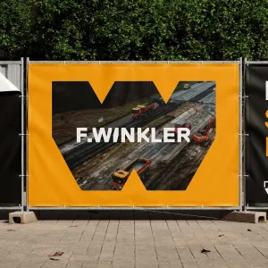Construction fence banner with a distinctive W-shape and an integrated image that makes the design immediately visible in its intended setting