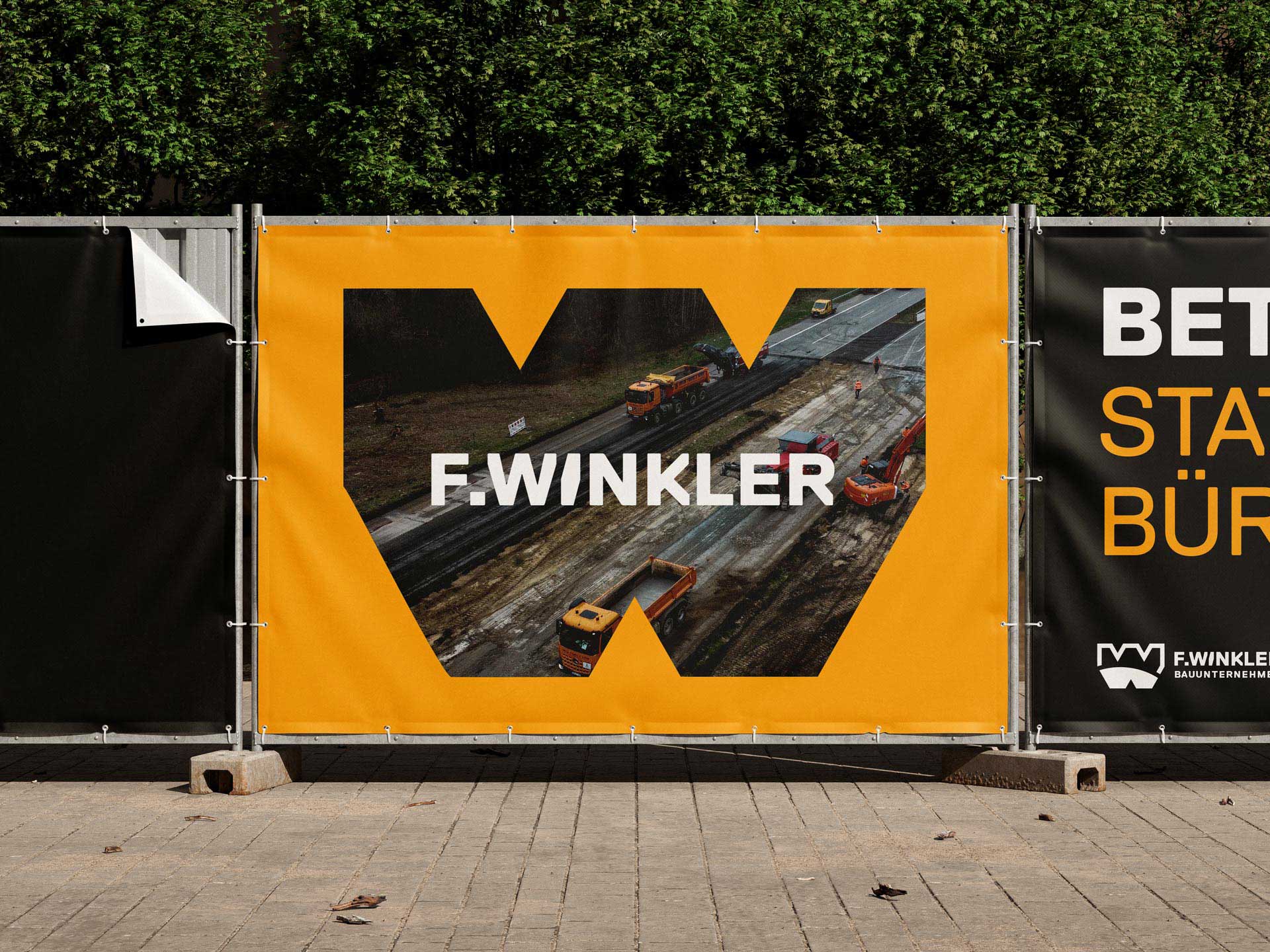 Bauzaunbanner mit markanter W-Form und integriertem Bild, das die Gestaltung direkt im Einsatzkontext sichtbar macht