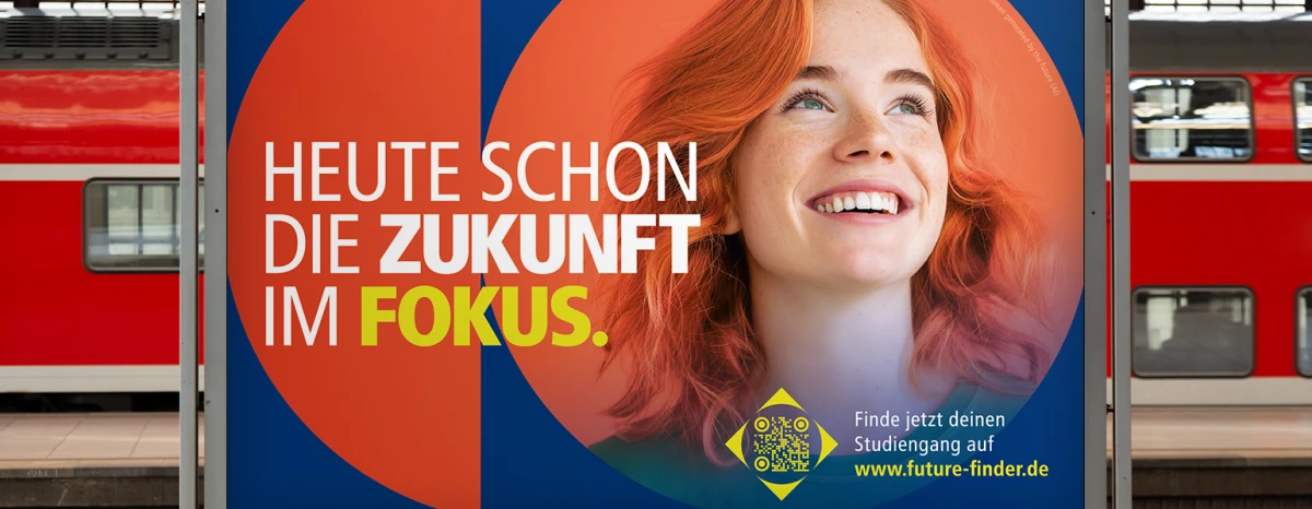 Eine Plakatwand auf einem Bahnsteig, im Hintergrund steht ein Zug auf dem Gleis. Auf dem Plakat ist das Haupt Motiv zu sehen. Die rothaarige Frau mit orangenem Hintergrund in einer geometrischen Form auf dunkelblauem Hintergrund. Darüber die Headline der ersten Kampagnen Phase. Heute schon die Zukunft im Fokus.
